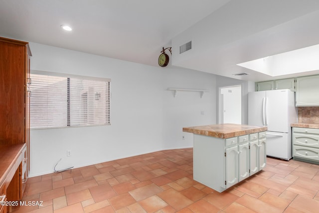 kitchen with white refrigerator and tasteful backsplash