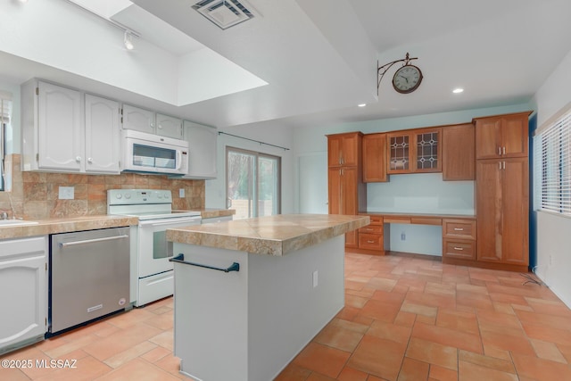 kitchen featuring decorative backsplash, white cabinetry, stove, and stainless steel dishwasher