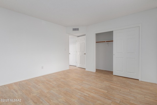 unfurnished bedroom featuring a closet and light wood-type flooring