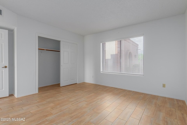 unfurnished bedroom featuring light hardwood / wood-style floors and a closet