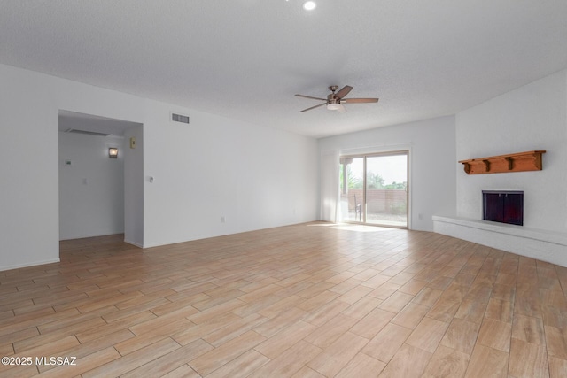 unfurnished living room with a textured ceiling and ceiling fan