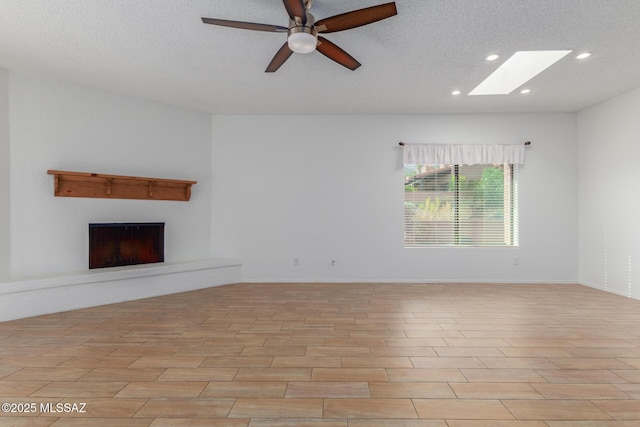 unfurnished living room with a textured ceiling and ceiling fan