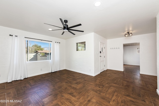 unfurnished room with dark parquet floors and ceiling fan