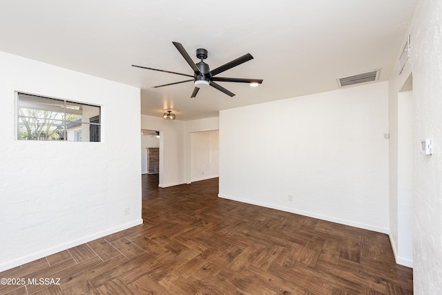 unfurnished room with ceiling fan and dark parquet floors