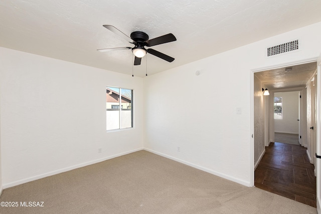 carpeted spare room featuring ceiling fan