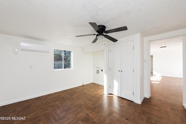 unfurnished room with ceiling fan, dark parquet floors, and a wall mounted AC