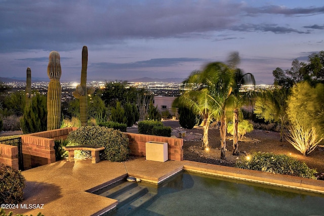 pool at dusk featuring a patio area