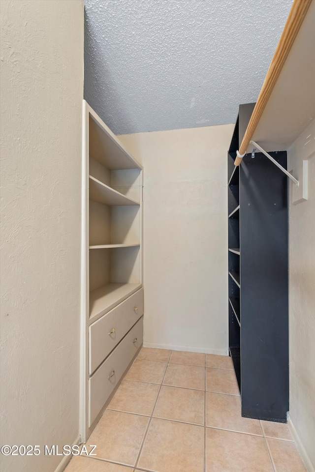 spacious closet featuring light tile patterned floors