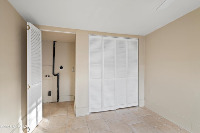 unfurnished bedroom with light tile patterned floors and a closet