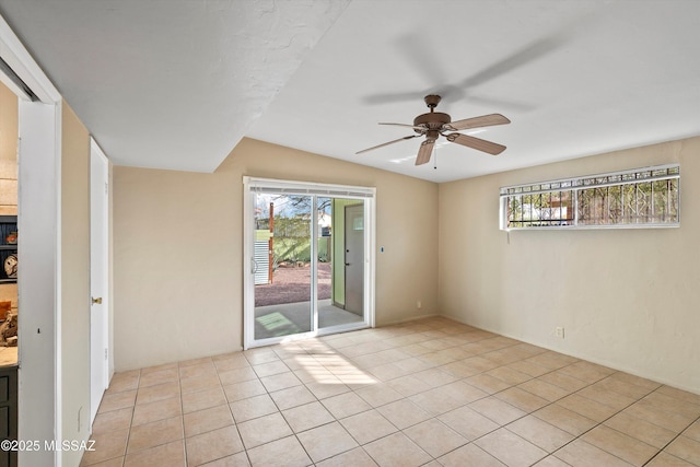 empty room with ceiling fan and light tile patterned floors