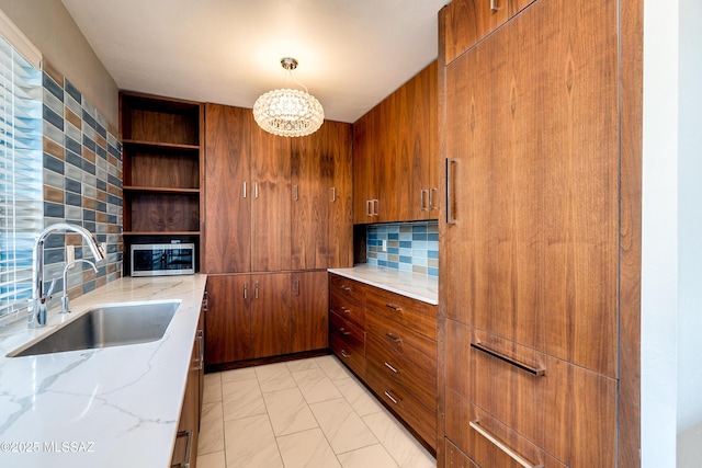 3000 E 6th St Unit A3, Tucson, AZ 85716 - kitchen featuring a sink, stainless steel microwave, open shelves, backsplash, and light stone counters