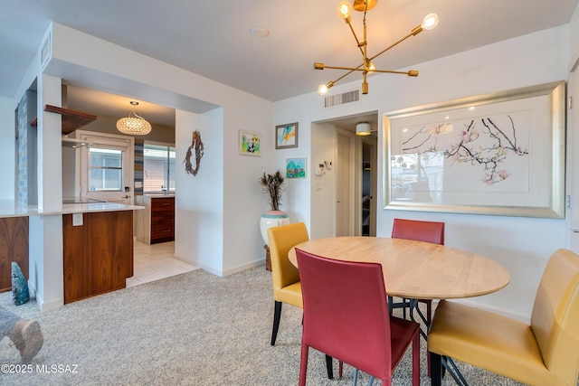 dining area with light carpet and a notable chandelier