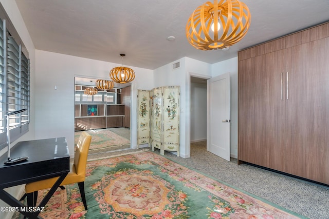 carpeted office with an inviting chandelier