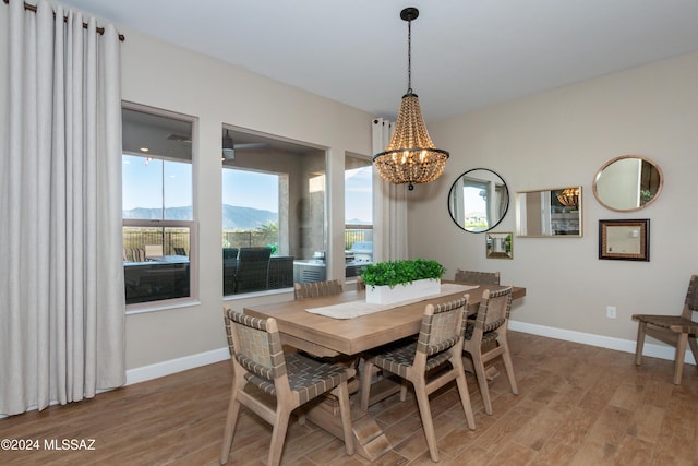 dining room featuring hardwood / wood-style floors, a mountain view, and a notable chandelier