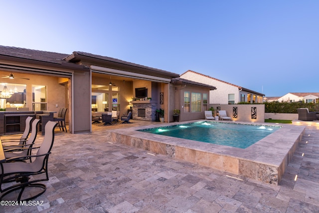 view of pool with a patio area, pool water feature, and a fireplace