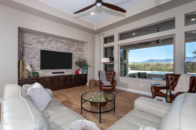 living room with ceiling fan and light wood-type flooring