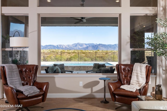 living area with a mountain view, ceiling fan, and hardwood / wood-style flooring