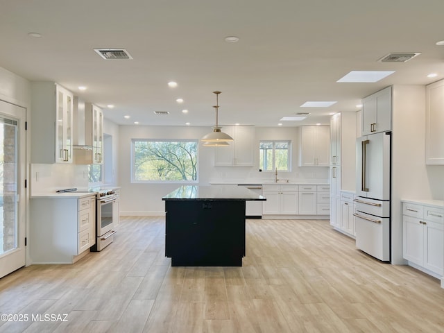 kitchen featuring high end white refrigerator, stainless steel electric range, visible vents, and dishwasher