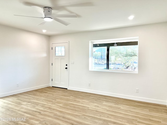 foyer entrance featuring baseboards, a ceiling fan, and light wood-style floors