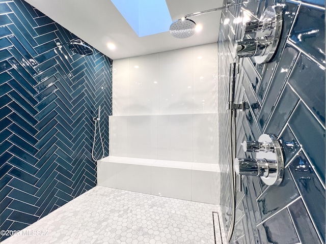 bathroom featuring tile patterned flooring, a tile shower, and tile walls