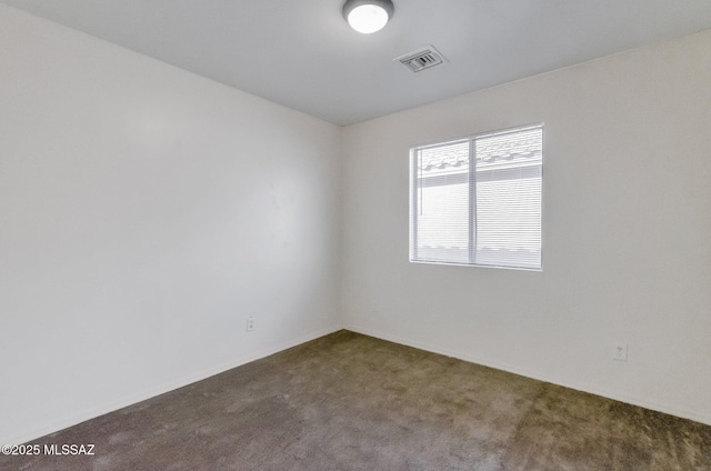 unfurnished room featuring dark carpet