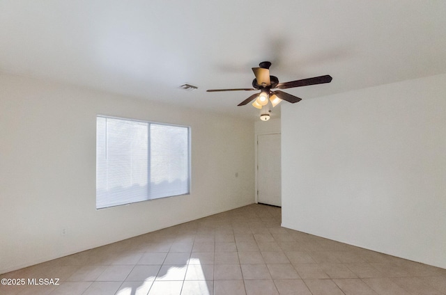 tiled spare room with ceiling fan