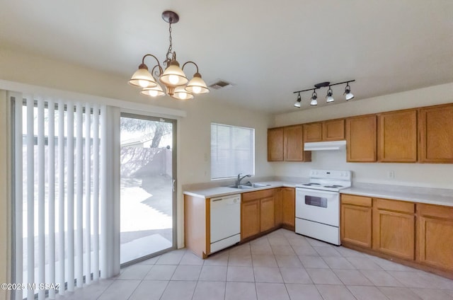 kitchen with white appliances, sink, light tile patterned floors, decorative light fixtures, and a chandelier