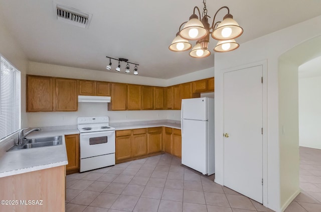 kitchen featuring white appliances, sink, light tile patterned floors, a chandelier, and hanging light fixtures