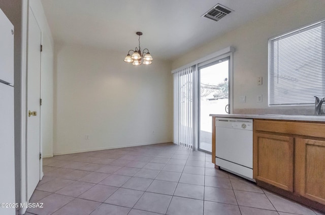 kitchen with sink, an inviting chandelier, white dishwasher, decorative light fixtures, and light tile patterned floors