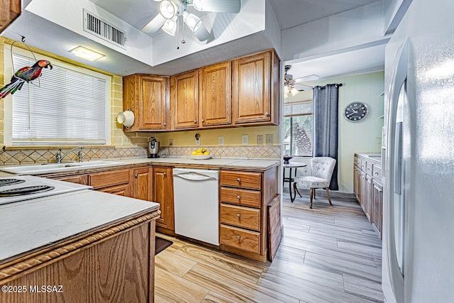 kitchen with backsplash, ceiling fan, sink, and white appliances