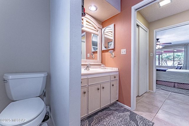 bathroom featuring tile patterned floors, a textured ceiling, vanity, ceiling fan, and toilet