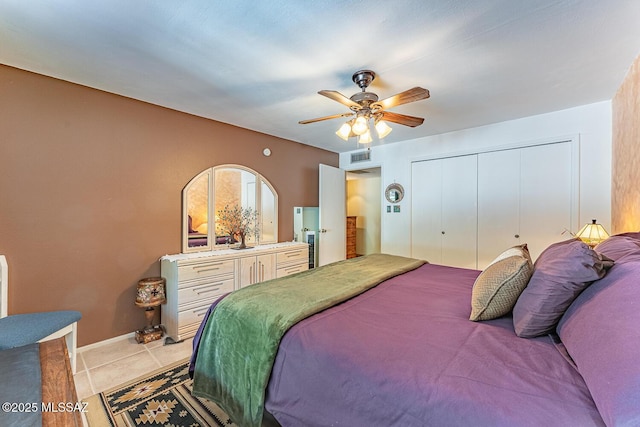 bedroom featuring ceiling fan, a closet, and light tile patterned floors