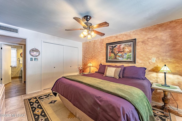 tiled bedroom featuring ceiling fan and a closet