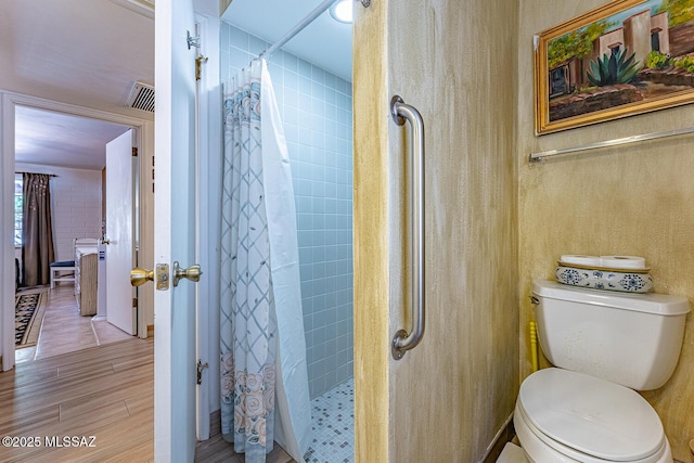 bathroom with a shower with shower curtain and toilet