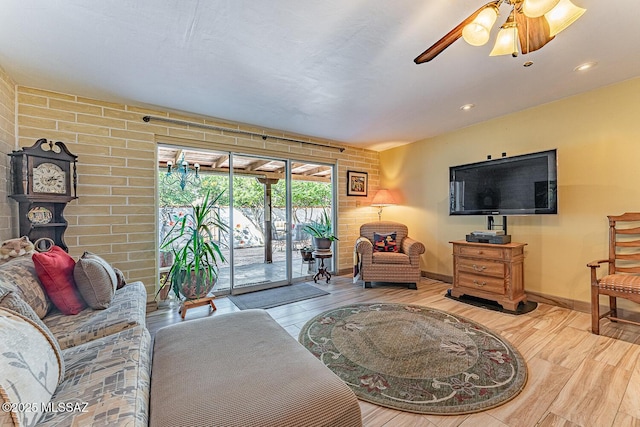 living room featuring ceiling fan and light hardwood / wood-style flooring