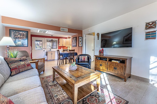 living room featuring sink and light hardwood / wood-style flooring