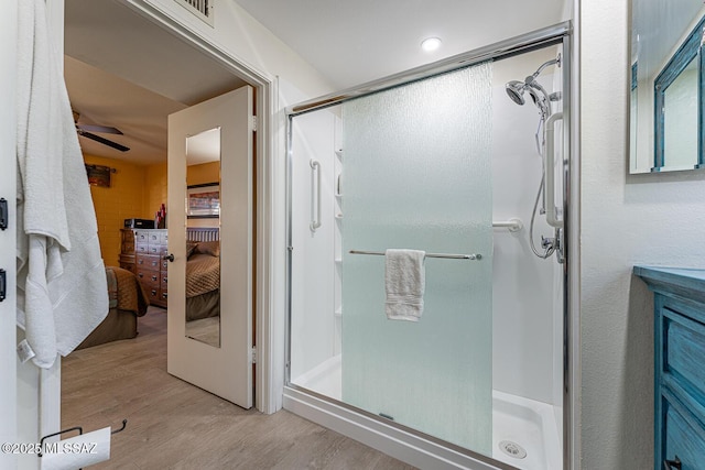 bathroom with hardwood / wood-style flooring and a shower with door