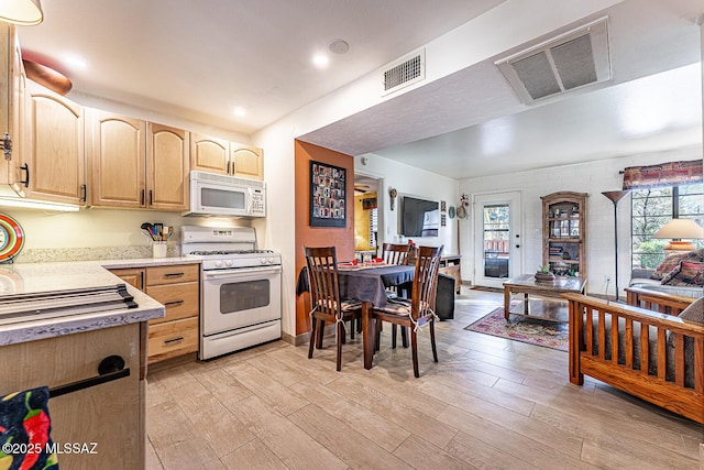 kitchen with light hardwood / wood-style floors, light brown cabinets, and white appliances