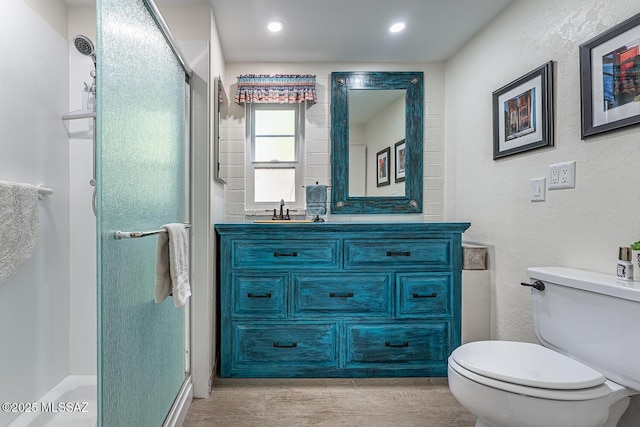 bathroom with vanity, a shower with shower door, and toilet