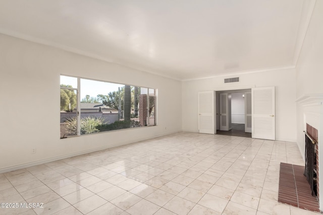 unfurnished living room with ornamental molding and a brick fireplace