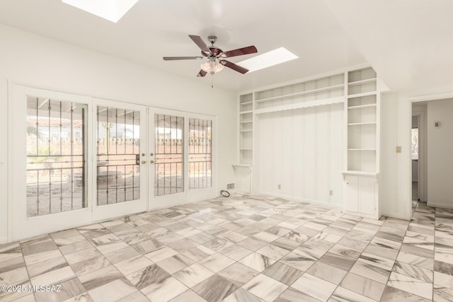 unfurnished living room featuring french doors, a skylight, ceiling fan, and a healthy amount of sunlight