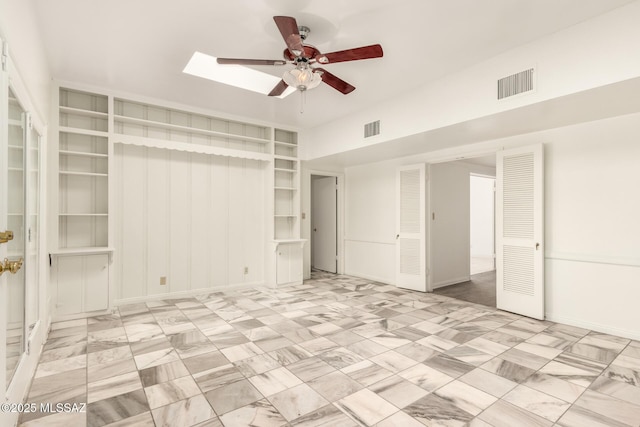 unfurnished room featuring ceiling fan and a skylight