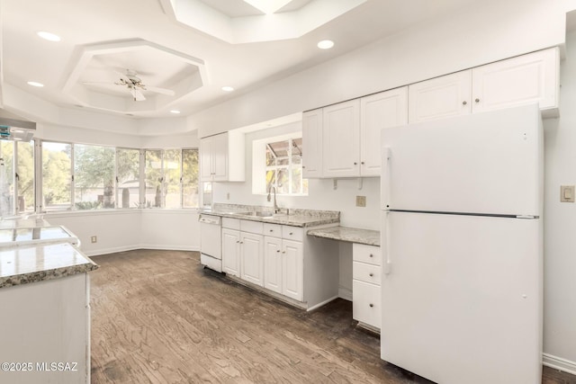 kitchen featuring white appliances, white cabinetry, ceiling fan, and a raised ceiling