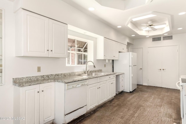 kitchen featuring white appliances, ceiling fan, a tray ceiling, sink, and white cabinetry