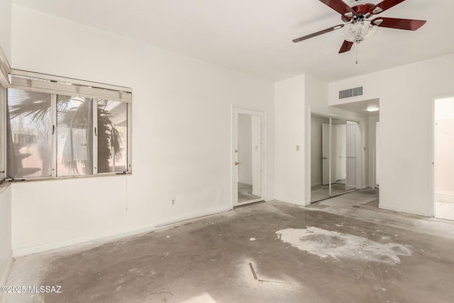 unfurnished room featuring ceiling fan and concrete floors