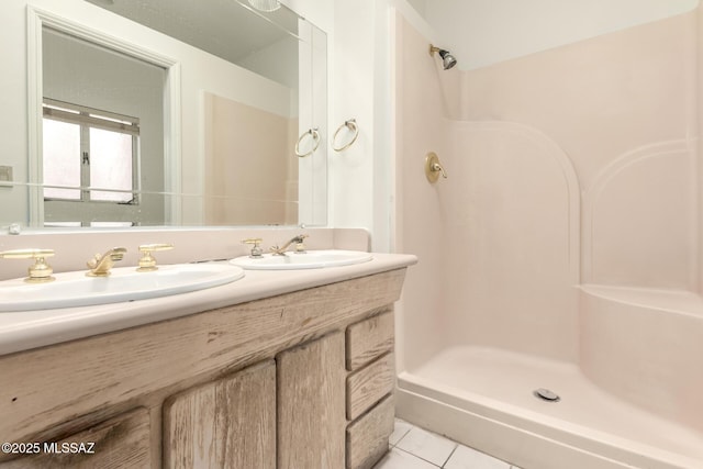 bathroom featuring tile patterned flooring, walk in shower, and vanity