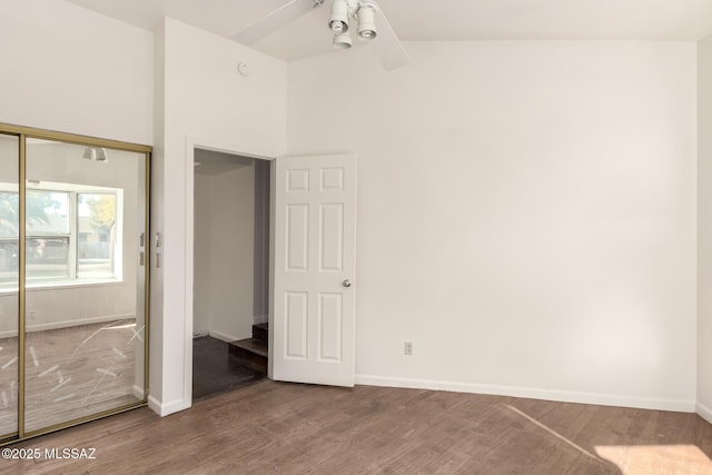 unfurnished bedroom featuring high vaulted ceiling, hardwood / wood-style floors, a closet, and ceiling fan