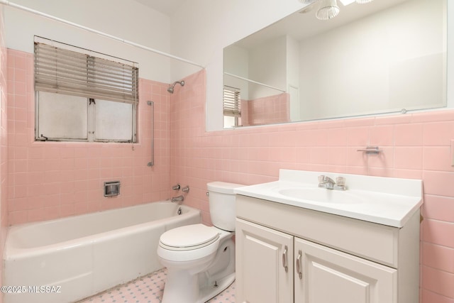 full bathroom with tile walls, toilet, vanity, and tiled shower / bath