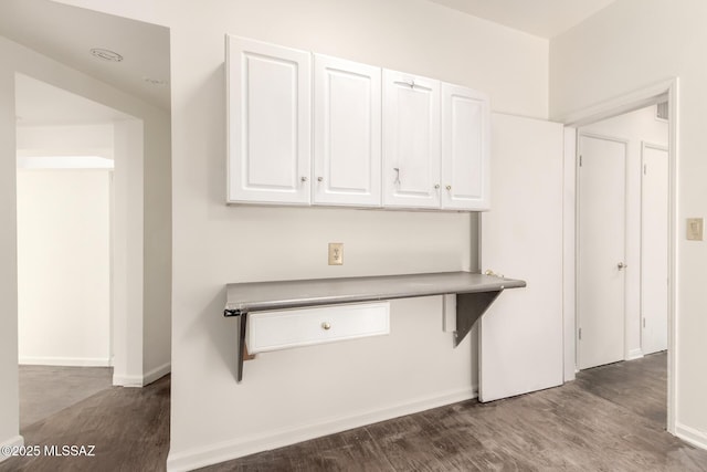 kitchen with dark hardwood / wood-style flooring and white cabinetry