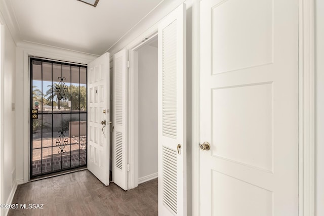 entryway with crown molding and wood-type flooring